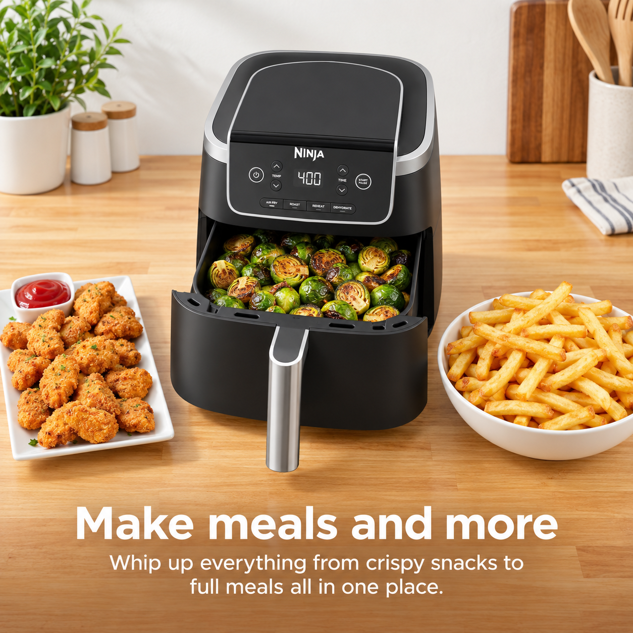 Air fryer preparing vegetables alongside fries and crispy chicken